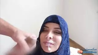 فتاة عربية ترتدي حجاب أزرق تأخذ عدة قذفات على وجهها